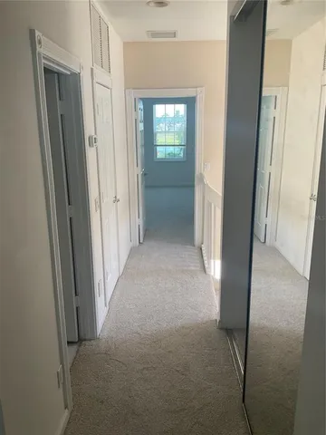 a view of a hallway to rooms