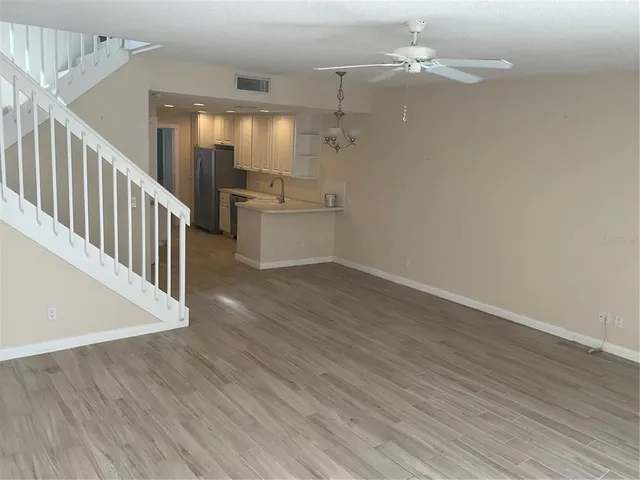 a view of a kitchen with wooden floor and a kitchen space