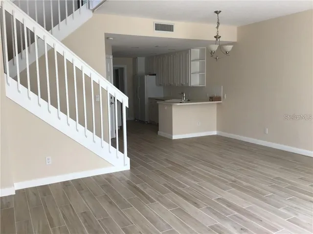 a view of a hallway with wooden floor and staircase