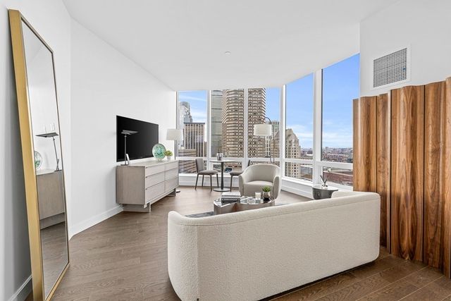 a living room with furniture a large window and a flat screen tv