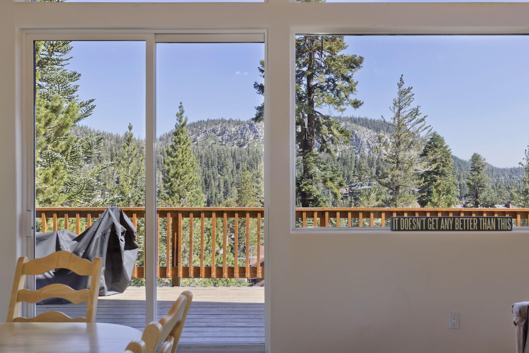 492 John Muir Road Mammoth Lakes, CA 93546 - Photo 12 of 33 Sliding glass door opening to an outdoor deck with wood railings, framed by expansive windows with m