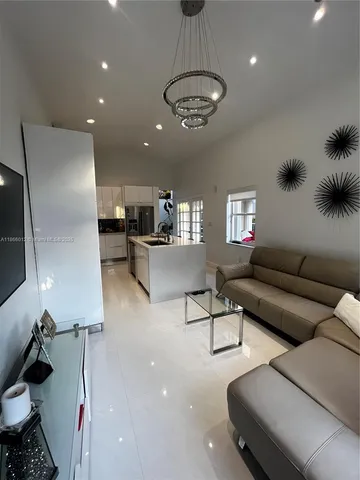 a living room with furniture and a chandelier