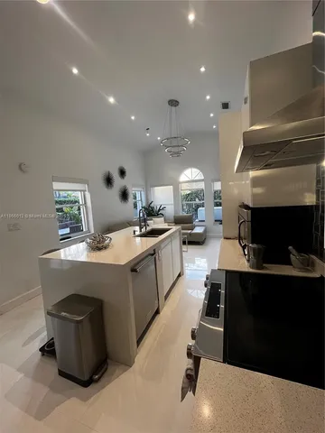 a kitchen with kitchen island sink stove and refrigerator