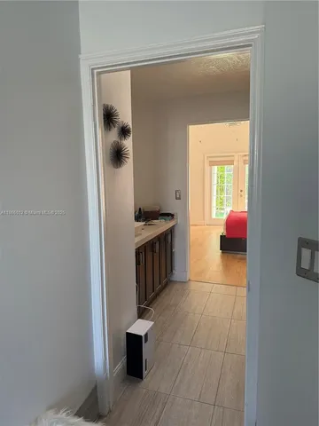 a walk in closet with wooden floor and a bathroom