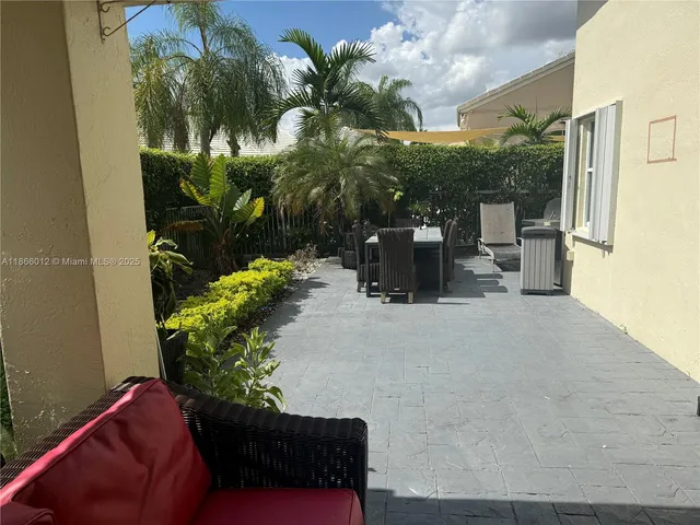 a vase of flowers sitting on a floor in front of a door
