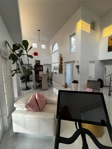 a living room with furniture a mirror and white walls