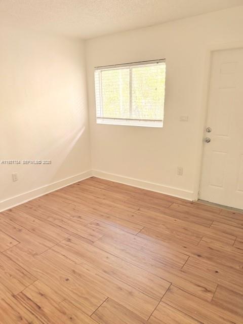 1030 Northeast 80th Street, Unit 1 Miami, FL 33138 - Photo 13 of 22 an empty room with wooden floor and windows