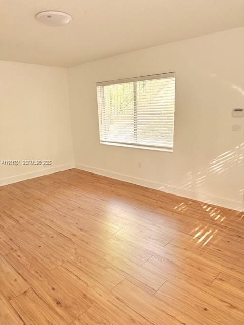 1030 Northeast 80th Street, Unit 1 Miami, FL 33138 - Photo 15 of 22 an empty room with wooden floor and windows