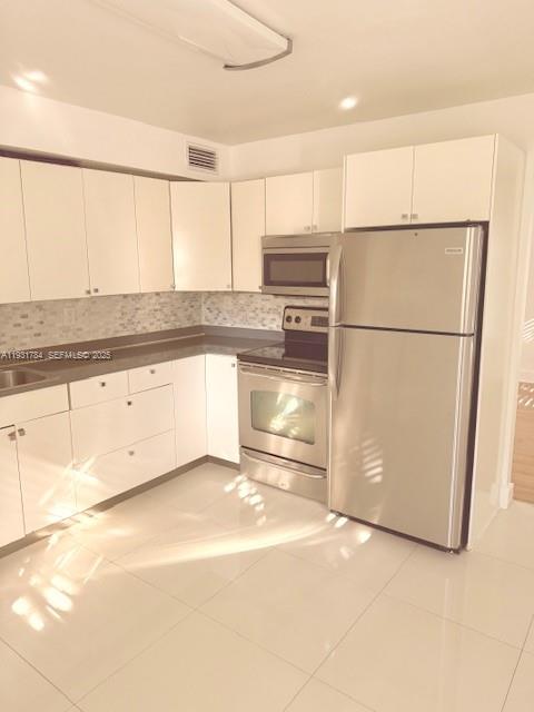 1030 Northeast 80th Street, Unit 1 Miami, FL 33138 - Photo 8 of 22 a kitchen with stainless steel appliances a refrigerator sink and cabinets