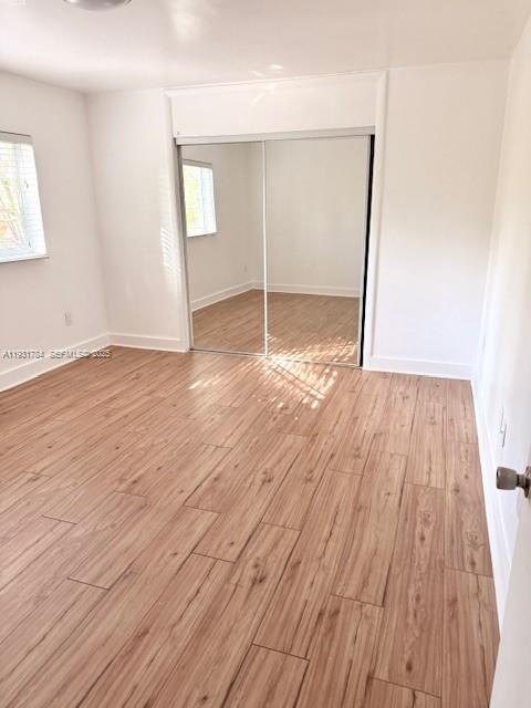 1030 Northeast 80th Street, Unit 1 Miami, FL 33138 - Photo 9 of 22 an empty room with wooden floor and windows