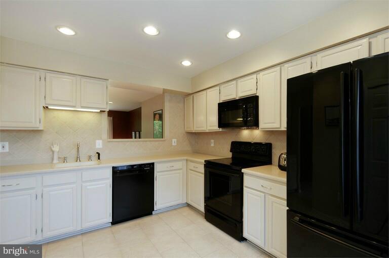 2038 Swans Neck Way Reston, VA 20191 - Photo 20 of 27 a kitchen with a sink a microwave a refrigerator and cabinets