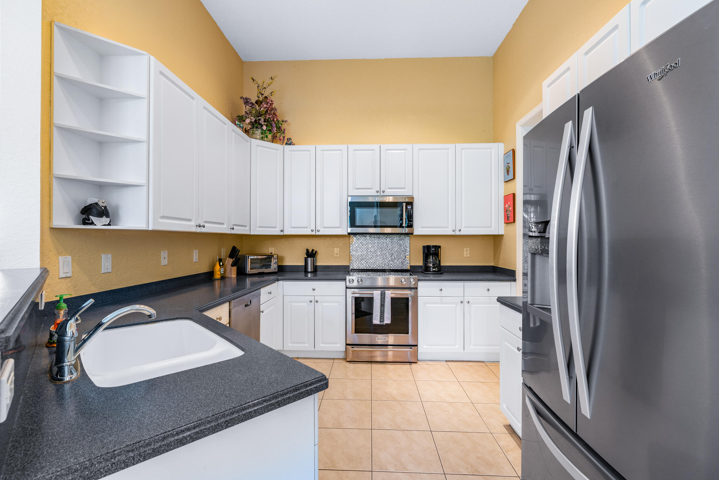 108 Palmfield Way Jupiter, FL 33458 - Photo 13 of 30 a kitchen with stainless steel appliances granite countertop a sink refrigerator and microwave