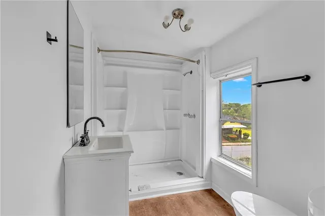 a bathroom with a shower a sink and a toilet