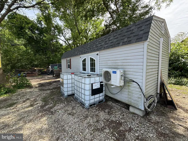 a view of a house with a yard chairs and wooden fence