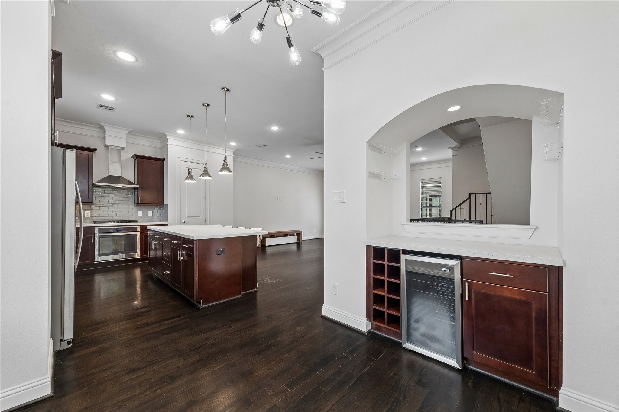 734 West 20th Street, Unit A Houston, TX 77008 - Photo 6 of 23 Open layout flows seamlessly from the kitchen to dining & living areas, highlighted by rich wood floors, crown molding & a built-in beverage center w/ wine storage.