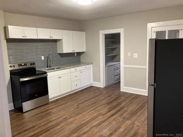 a kitchen with wooden floors and appliances
