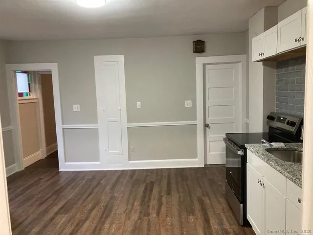 an empty room with wooden floor and cabinet