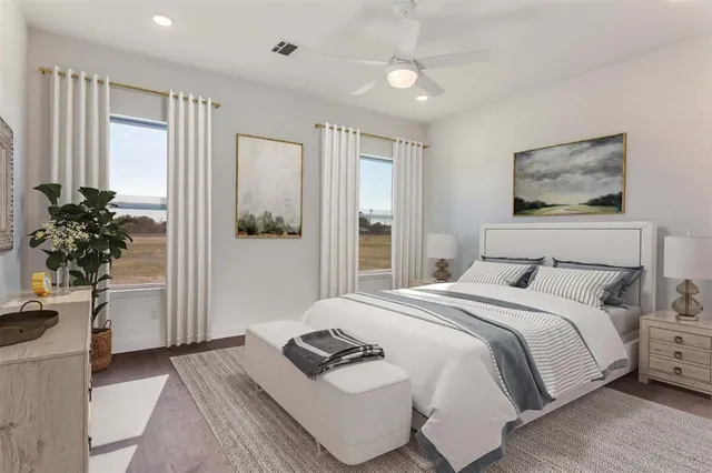 a bedroom with a large bed and a potted plant