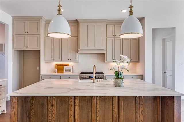 a kitchen with granite countertop a stove a sink dishwasher and a wooden cabinets