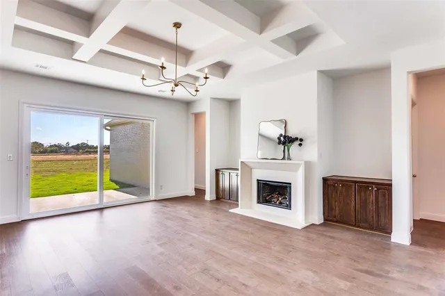 a view of an empty room with a fireplace and a window