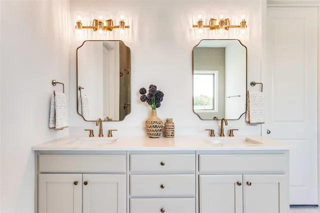 a bathroom with double vanity sinks and a mirror