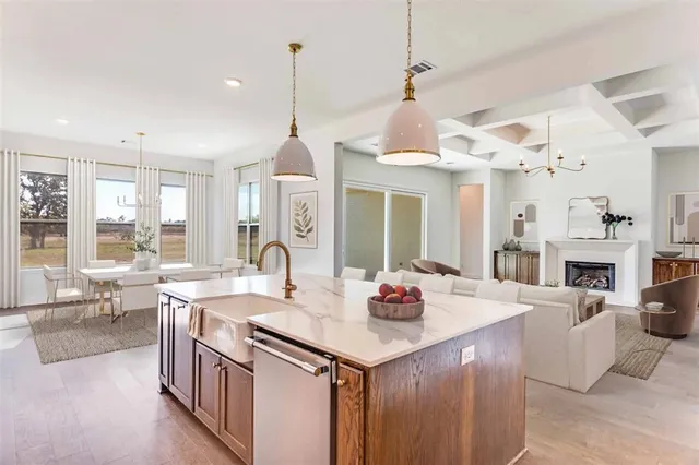 a view of a dining room and livingroom with furniture wooden floor a chandelier
