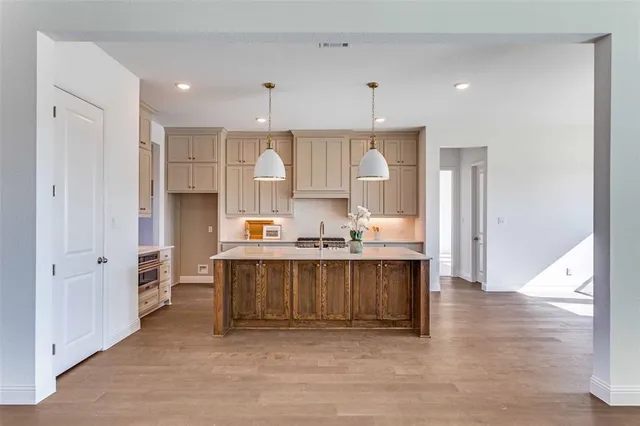 a view of kitchen with stainless steel appliances cabinets and wooden floor