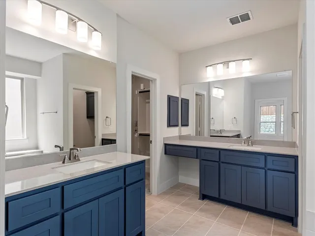 a bathroom with a double vanity sink and mirror with shower