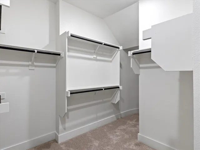a view of walk in closet with empty racks