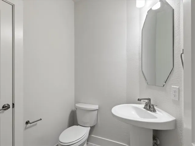 a bathroom with a sink toilet and a mirror