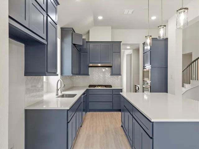 a kitchen with kitchen island a sink stove and refrigerator