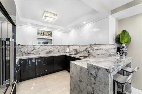 a kitchen with a sink a stove and chairs