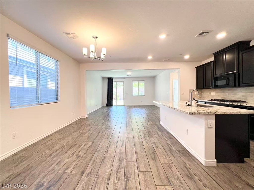 925 Bayberry Ridge Street Henderson, NV 89052 - Photo 27 of 27 An open floorplan seamlessly connects the kitchen and living areas, offering stylish flooring and abundant natural light.