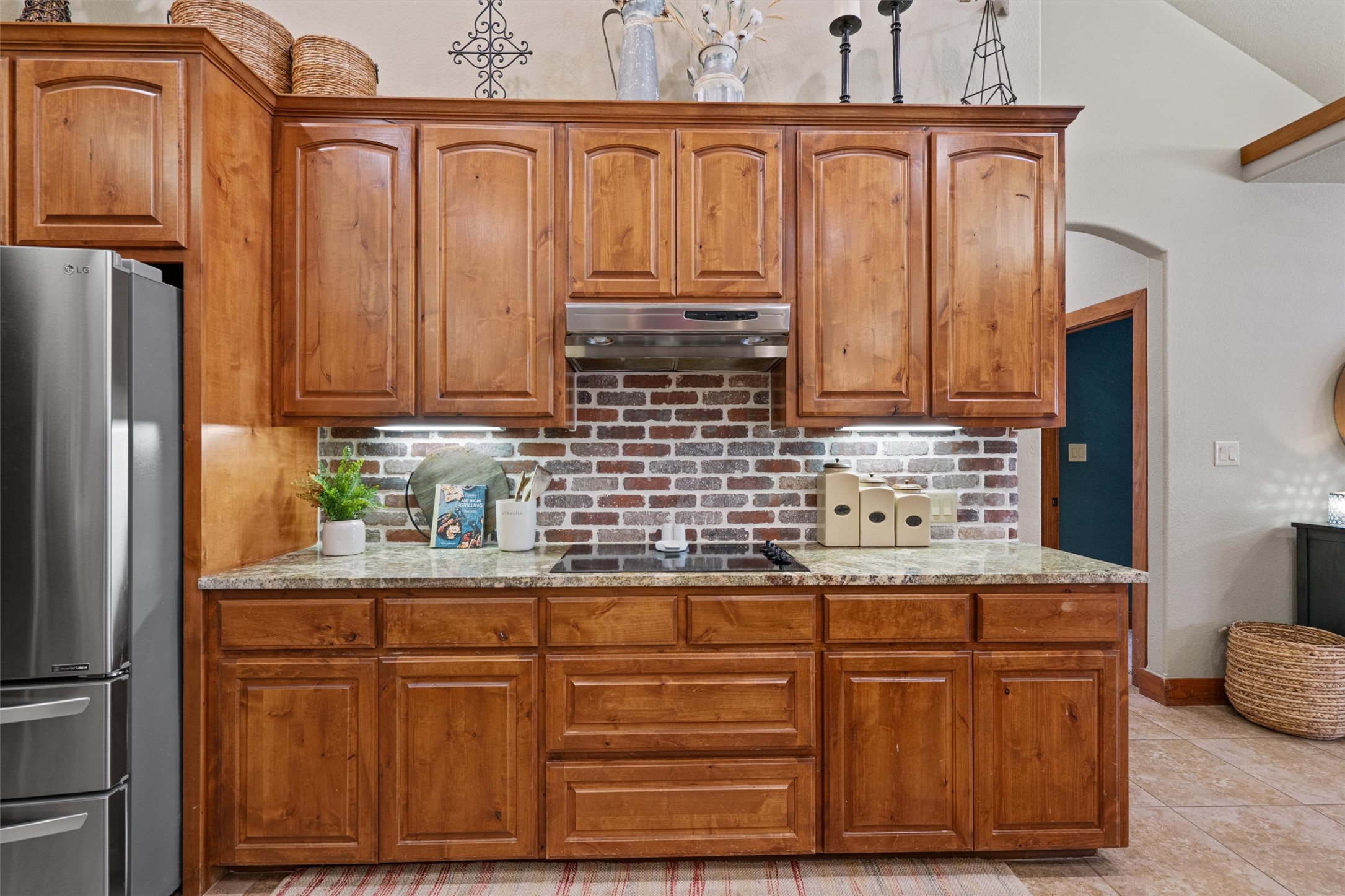 200 Little River Road Liberty Hill, TX 78642 - Photo 11 of 40 a kitchen with granite countertop wooden cabinets and stainless steel appliances