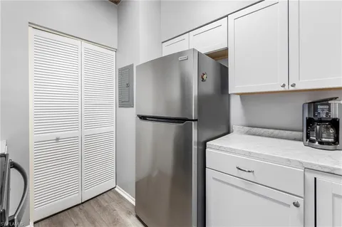 a close view of a refrigerator in kitchen and an empty room
