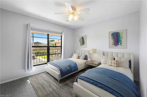 a bedroom with two beds and a large window