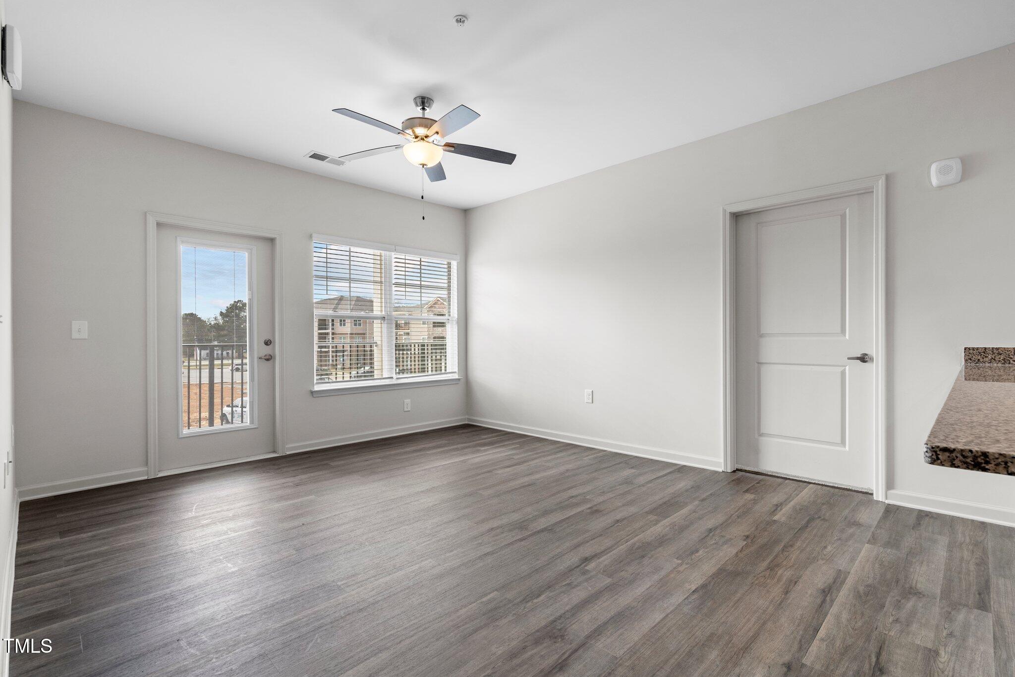 130 Grove Circle, Unit 204 Lillington, NC 27546 - Photo 12 of 28 a view of an empty room with wooden floor and a window