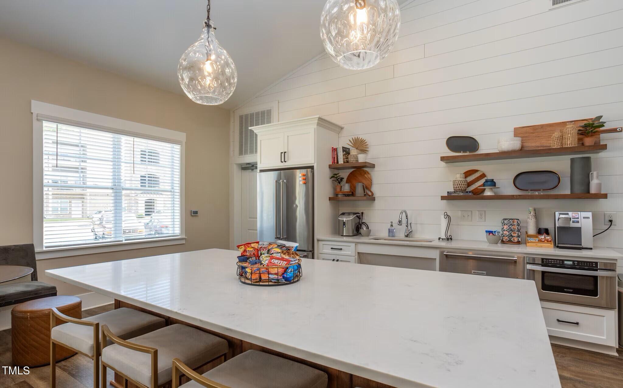 130 Grove Circle, Unit 204 Lillington, NC 27546 - Photo 21 of 28 a kitchen with stainless steel appliances a table and chairs in it