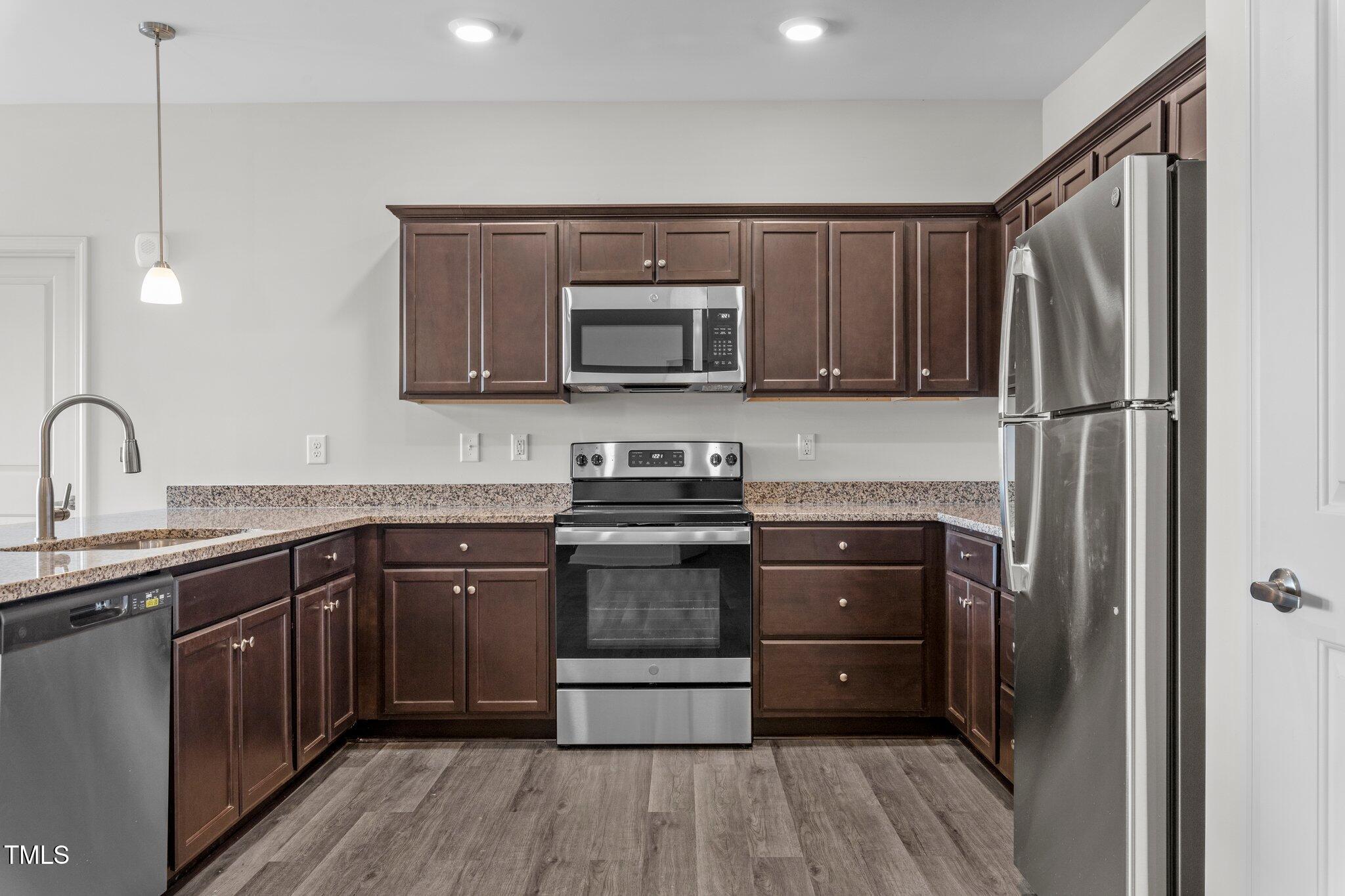 130 Grove Circle, Unit 204 Lillington, NC 27546 - Photo 6 of 28 a kitchen with a sink stove and microwave