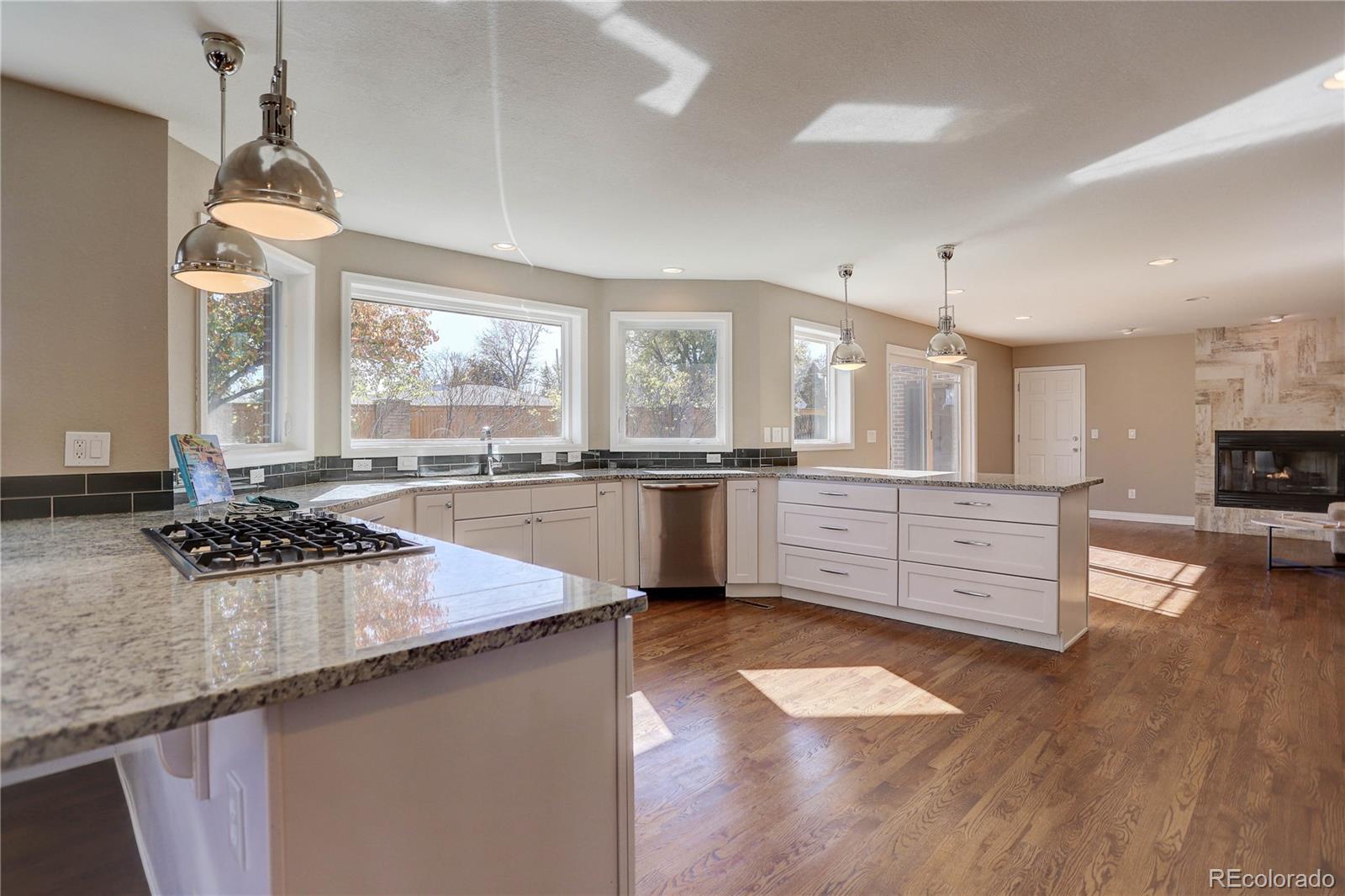 3804 Simms Street Wheat Ridge, CO 80033 - Photo 11 of 40 a kitchen with stainless steel appliances granite countertop a stove a sink and a wooden cabinets