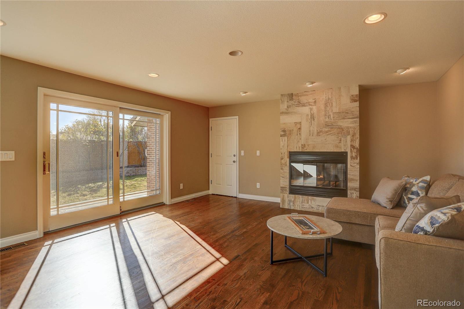 3804 Simms Street Wheat Ridge, CO 80033 - Photo 16 of 40 a living room with furniture and a fireplace