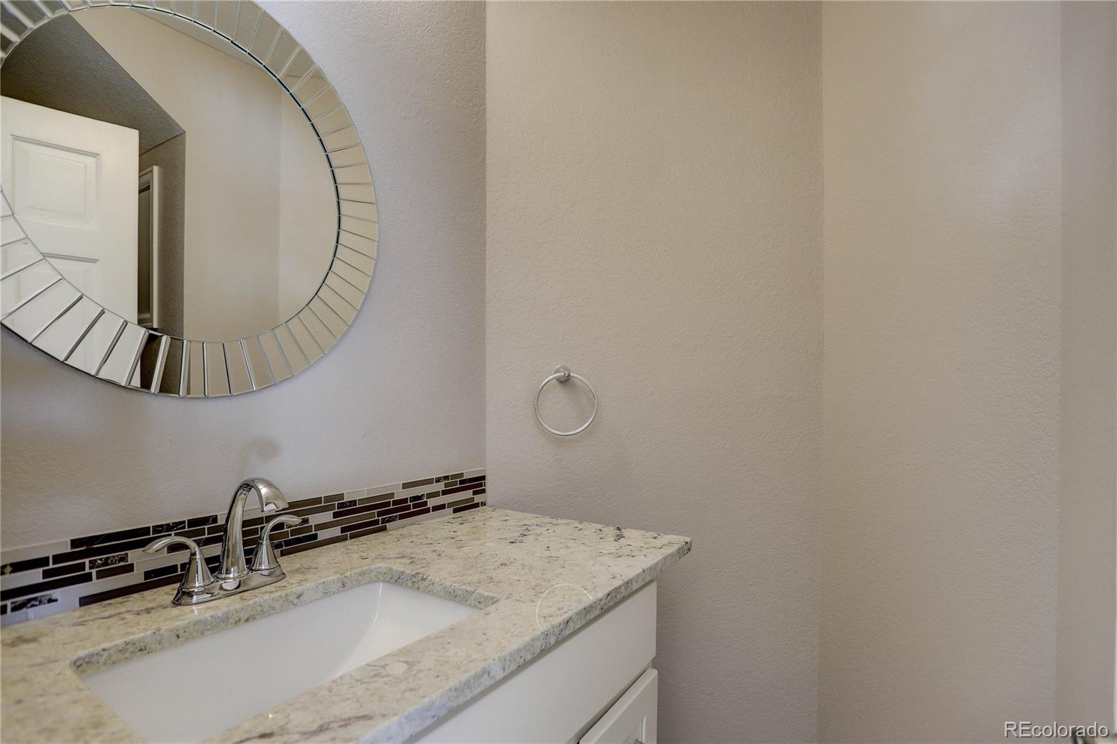 3804 Simms Street Wheat Ridge, CO 80033 - Photo 17 of 40 a bathroom with a granite countertop sink and a mirror