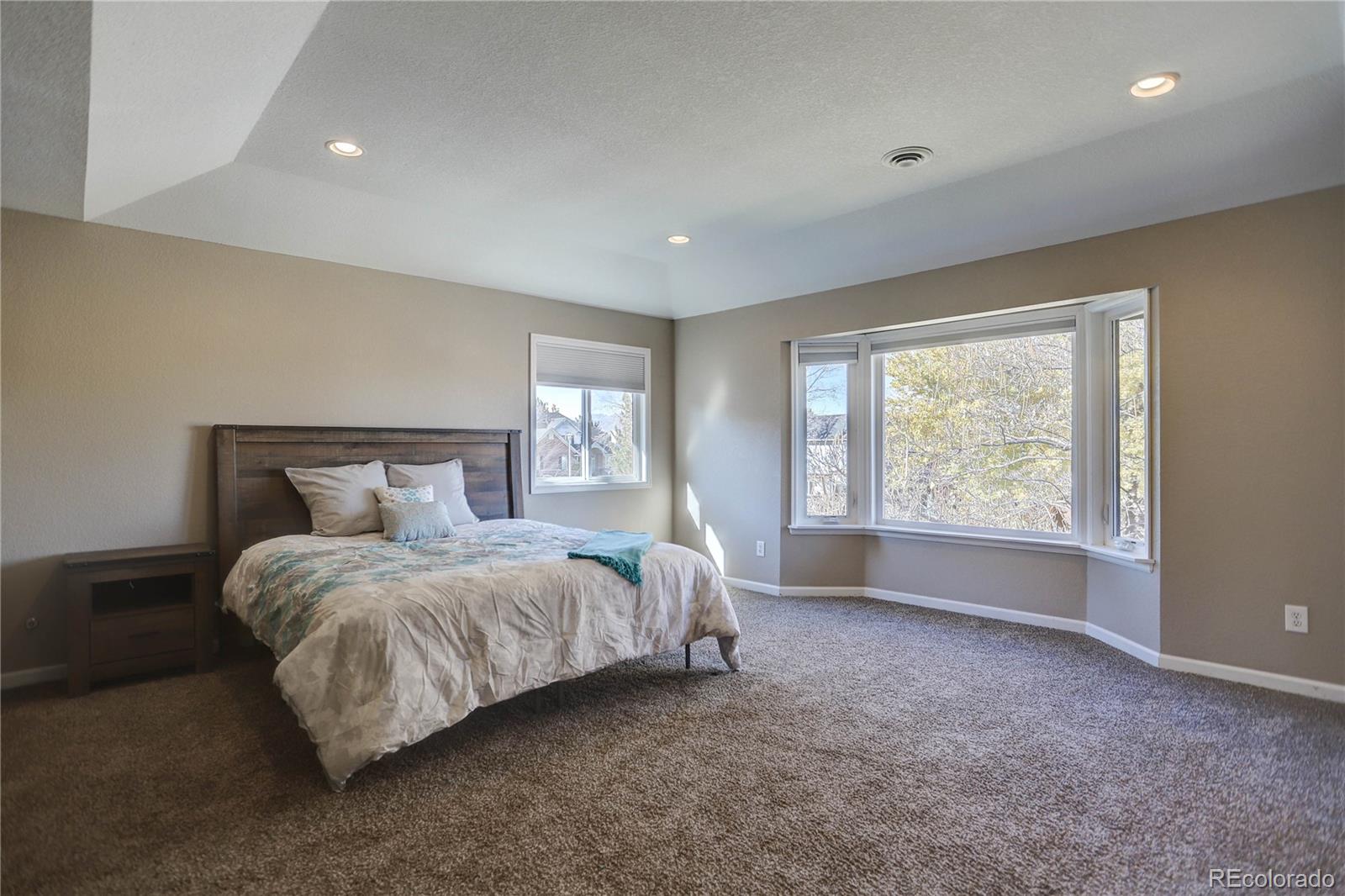 3804 Simms Street Wheat Ridge, CO 80033 - Photo 22 of 40 a spacious bedroom with a bed and a window