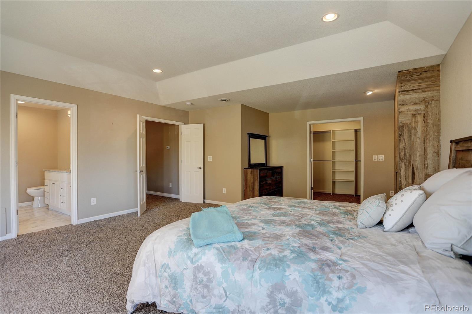 3804 Simms Street Wheat Ridge, CO 80033 - Photo 23 of 40 a spacious bedroom with a large bed and walk in closet