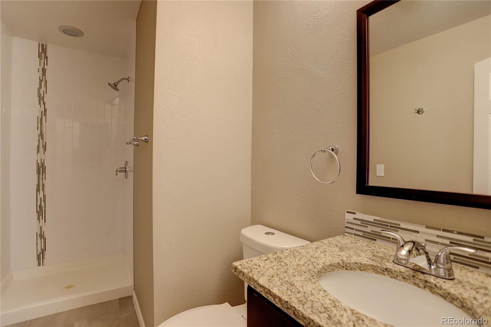 3804 Simms Street Wheat Ridge, CO 80033 - Photo 31 of 40 a bathroom with a granite countertop sink and a mirror