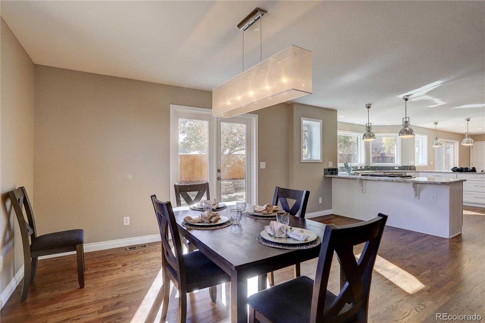 3804 Simms Street Wheat Ridge, CO 80033 - Photo 9 of 40 a view of a dining room with furniture and wooden floor