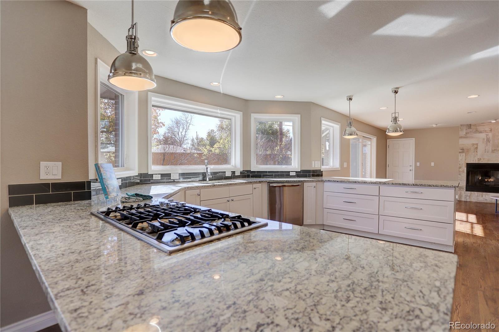 3804 Simms Street Wheat Ridge, CO 80033 - Photo 10 of 40 a kitchen with stainless steel appliances granite countertop a stove a sink and a refrigerator