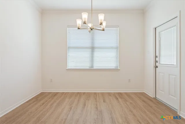 an empty room with wooden floor and window