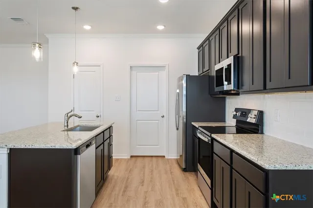 a kitchen with stainless steel appliances granite countertop a sink stove and refrigerator