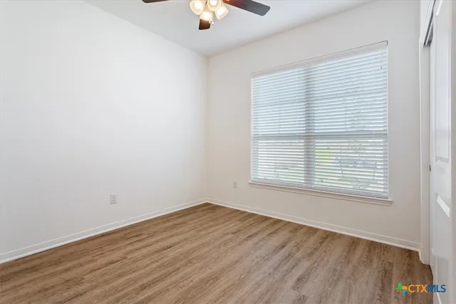 an empty room with a window and wooden floor